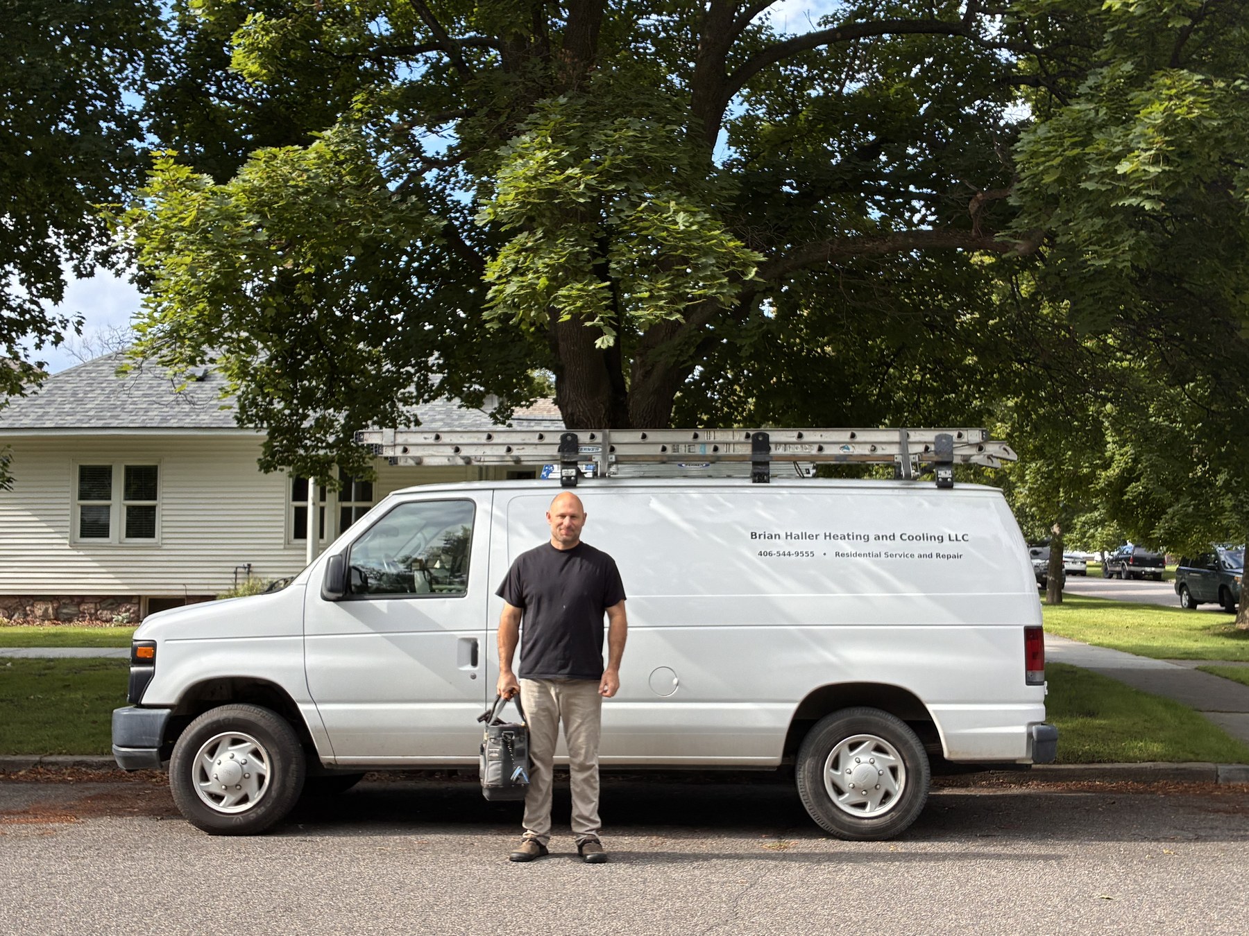 Brian Haller standing beside his heating and cooling service van